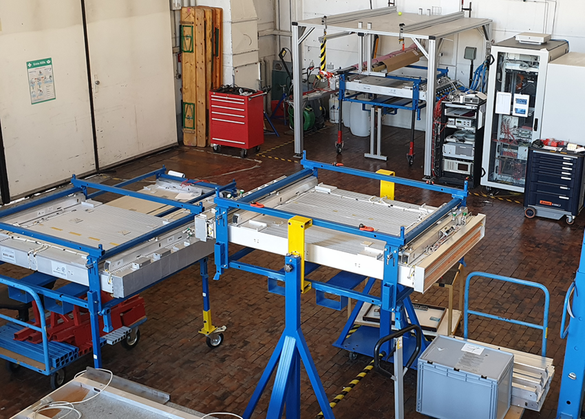 Muon chambers for the ATLAS experiments in several production states in the experimental hall. The  chamber front left is ready for shipping to CERN, the chamber on the right is waiting for installation of  read-out electronics. In the background a chamber undergoes its final test before transport. (Photo: H. Kroha/MPP)