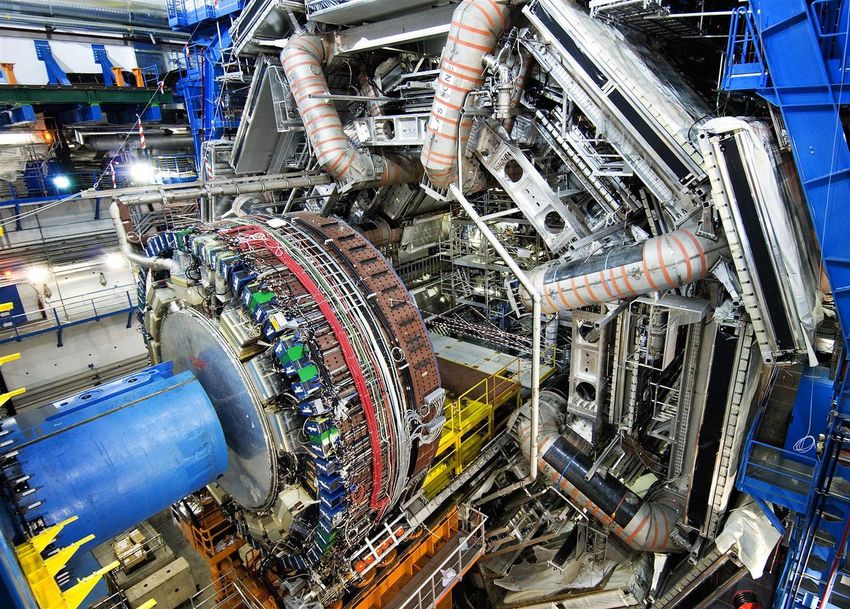 Blick in den geöffneten ATLAS-Detektor: Zu erkennen sind drei der äußeren Myonkammern (rechts), die orange gestreiften, 5x25-Meter großen Magnetspulen sowie die Endkappe des hadronischen Kalorimeters (Mitte). (Foto: ATLAS/CERN)